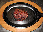 Lahodný steak ugrilovaný na otevřeném ohni.