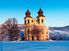 Pohled z Javořích hor k hřebeni Broumovských stěn. Šonovský kostel je nejodlehlejší kostel slavné broumovské skupiny kostelů. Byl postaven v letech 1727–1730 podle plánů K. I. Dientzenhofera.

