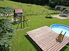 Dětské hřiště a bazén v zahradě penzionu Myslivna.