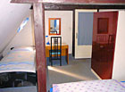 Modrý čtyřlůžkový pokoj v patře chalupy.
