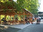 Dřevěný přístřešek pro venkovní stravování a parkoviště.