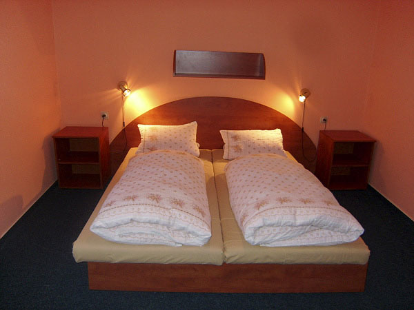 Manželská dvoulůžková postel v apartmánu rodinného domu