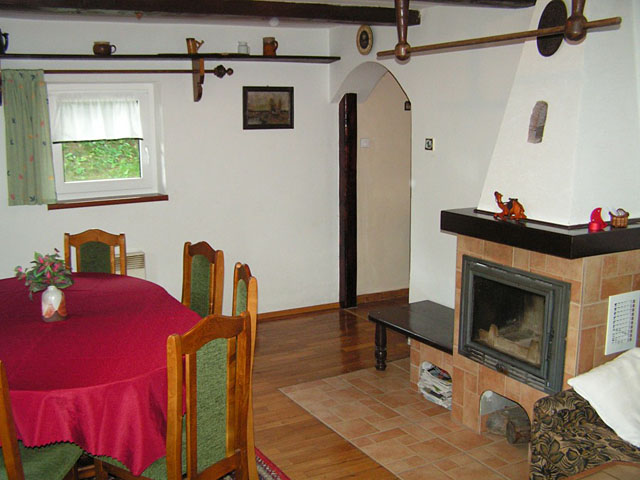 Obývací pokoj s posezením a krbem v přízemí chalupy