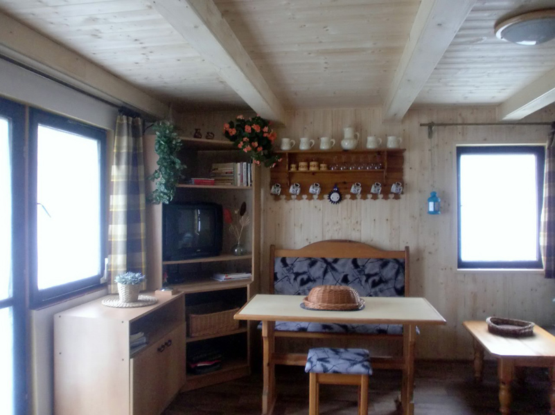 Obývací pokoj s kuchyní a krbem | chata v Klení