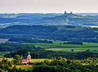 V popředí snímku kostel sv. Vavřince na okraji obce Tatobity, v pozadí typická silueta zříceniny hradu Trosky.

