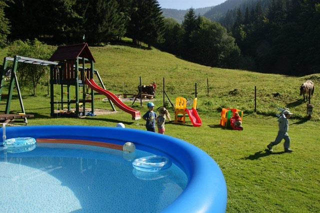 Dětské hřiště a bazén v zahradě penzionu Myslivna
