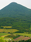 Hora Milešovka je s nadmořskou výškou 837 m nejvyšší horou Českého středohoří. Také se jedná o největrnější místo a lokalitu s nejvyšším výskytem bouřek v České republice. Foto: pohled z cesty mezi Kocourovem a Milešovem.

